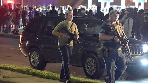 Kyle Rittenhouse, left, carries an AR-15-style rifle in Kenosha, Wisconsin, on August 25, 2020.