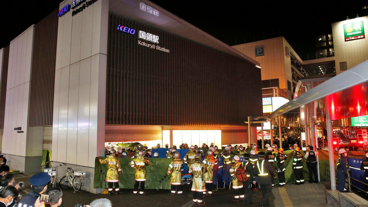 Emergency workers and police officers on the scene at a train station in Tokyo, Sunday Oct. 31, 2021.