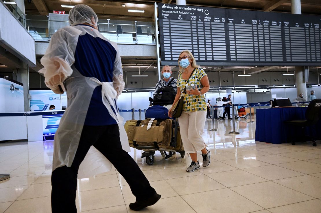 International visitors follow a health official inside the arrival terminal at Suvarnabhumi International Airport on November 1, 2021.