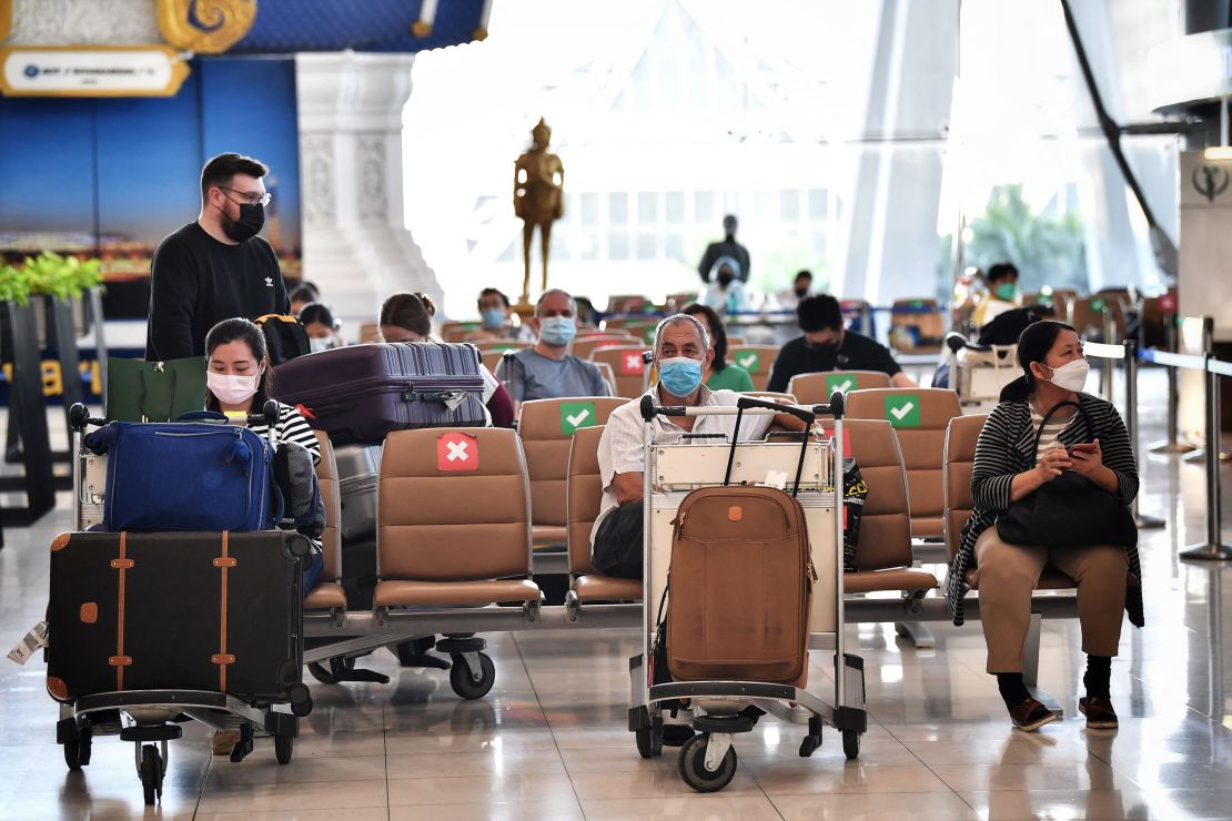 International visitors await instructions from health officials inside the arrival terminal at Suvarnabhumi International Airport.
