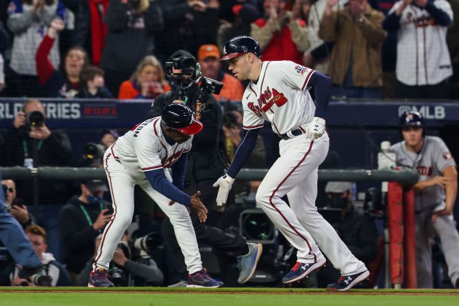 Braves first baseman Freddie Freeman high fives third base coach Ron Washington after hitting a solo home run on Sunday. Freeman's <a href="index.php?page=&url=https%3A%2F%2Fwww.cnn.com%2Fsport%2Flive-news%2Fworld-series-2021-braves-astros-game-5%2Fh_7691896754fc7c08a9b5327e21ec2261" target="_blank">460-foot home run to right-center</a> is his longest of the season, and tied for the biggest smash of his career.