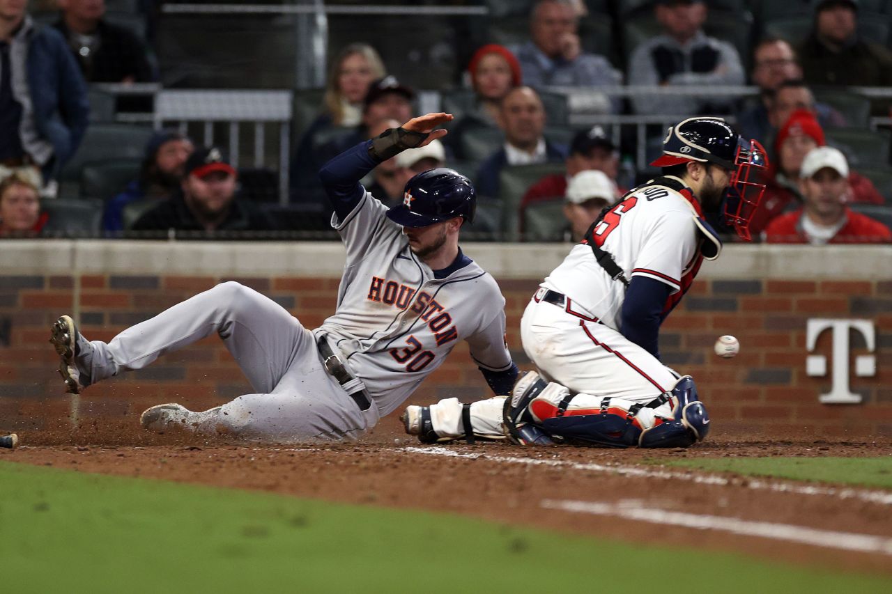 Houston Astros right fielder Kyle Tucker slides into home plate safely past Braves catcher Travis d'Arnaud during the seventh inning.