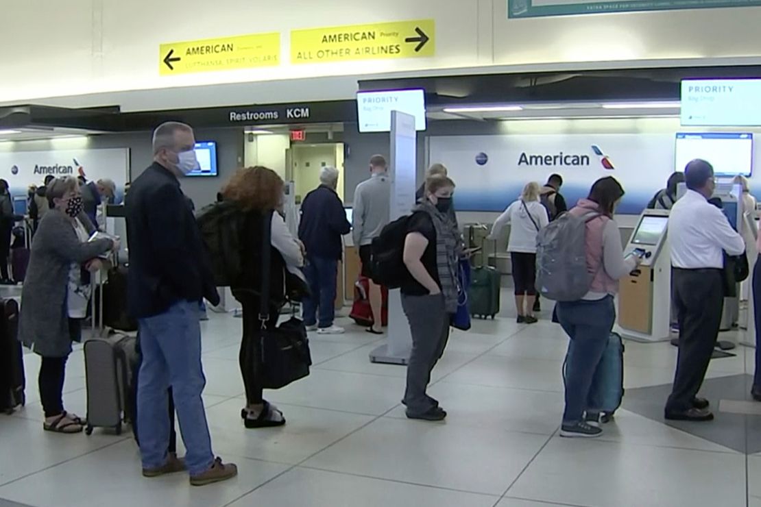 People wait in line at an American Airlines counter at an airport in Charlotte, on Sunday. The airline has canceled more than 800 flights on Sunday, or about 20% of its schedule for the day.