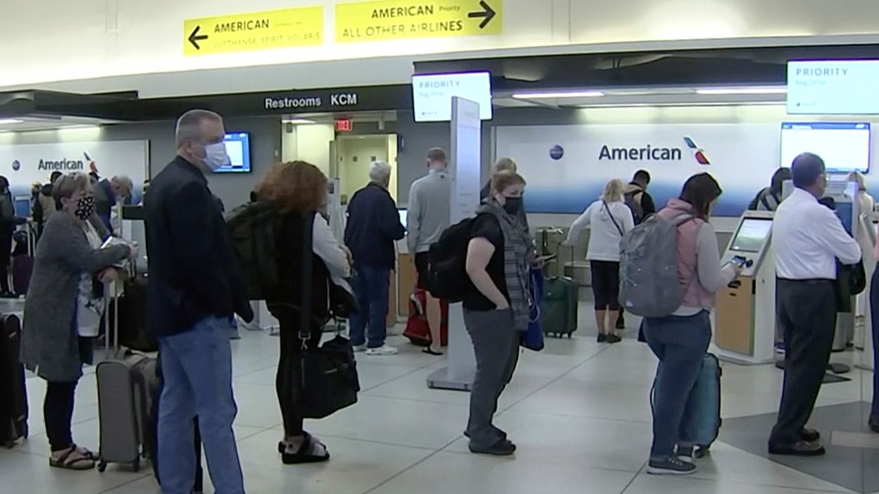 People wait in line at an American Airlines counter at an airport in Charlotte, on Sunday. The airline has canceled more than 800 flights on Sunday, or about 20% of its schedule for the day.