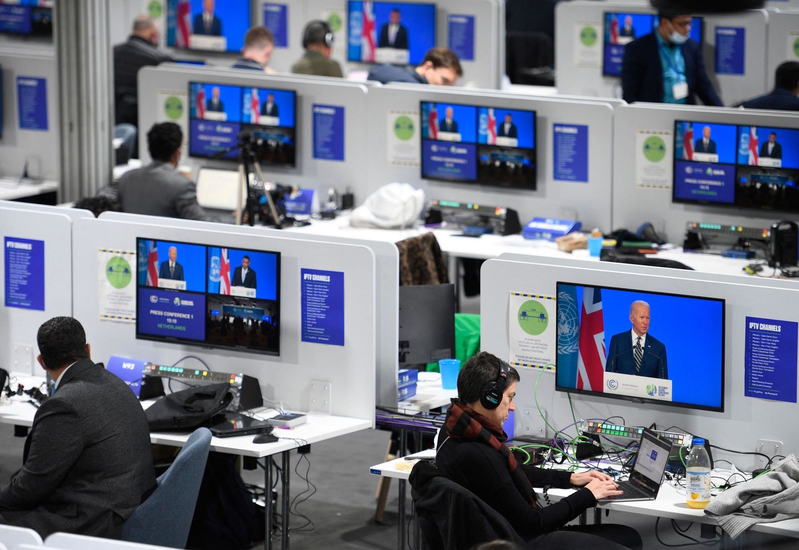 Journalists take notes as they listen to Biden's speech at the climate summit on Monday.