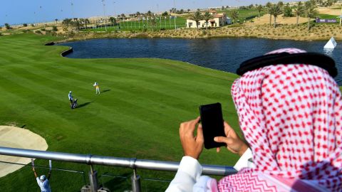 A Saudi man watches a golfer compete in the Saudi Ladies International golf tournament on November 15, 2020.