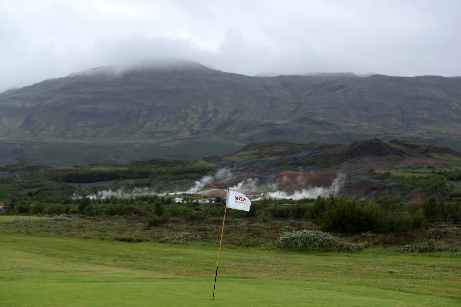The green on the eighth hole at Geysir Golf Club with the steam from the natural Geysirs behind.