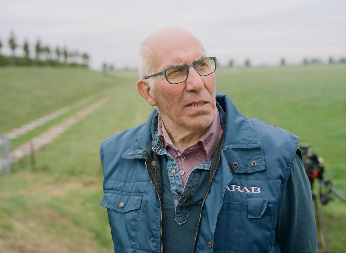 Nol Hooijmaijers stands next to the mound on which his dairy farm was rebuilt. Starting in 2010, Dutch authorities removed the dike that protected this spit of land from the Bergse Maas river, allowing the farmland to flood when the river swells.