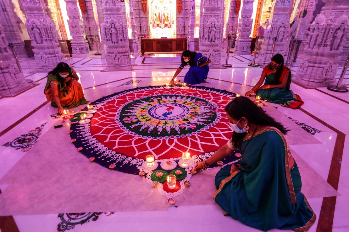 Women tend to a rangoli, a geometric pattern typically created using colored sand, during a Diwali celebration in Chino Hills, California, in 2020.