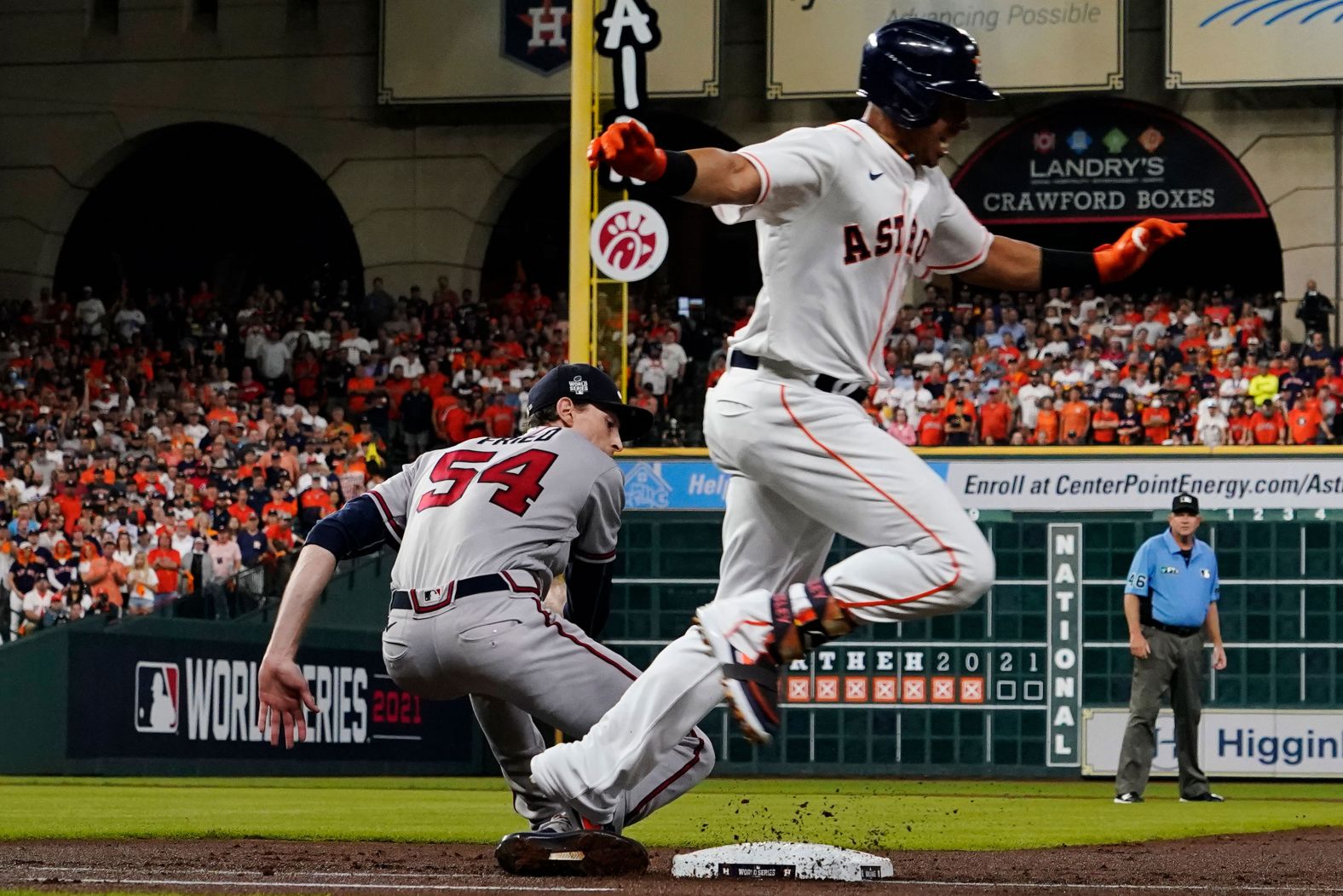 Michael Brantley of the Astros steps on Max Fried of the Braves on the way to first base.