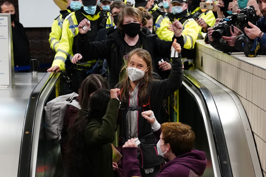 Thunberg gestures to cameras and supporters after arriving in Glasgow on Saturday ahead of the COP26 summit. 