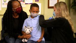 Nov 3, 2021; Plymouth, MI, USA; (L to R) Tyann Davis holds her son Cameron Davis's hand for comfort and support as IHA Plymouth Pediatrics medical assistant Madison Peterson gives him the Pfizer Covid vaccine in the IHA medical office in Plymouth, Michigan on Wednesday, Nov. 3, 2021.  Mandatory Credit: Eric Seals-USA TODAY NETWORK