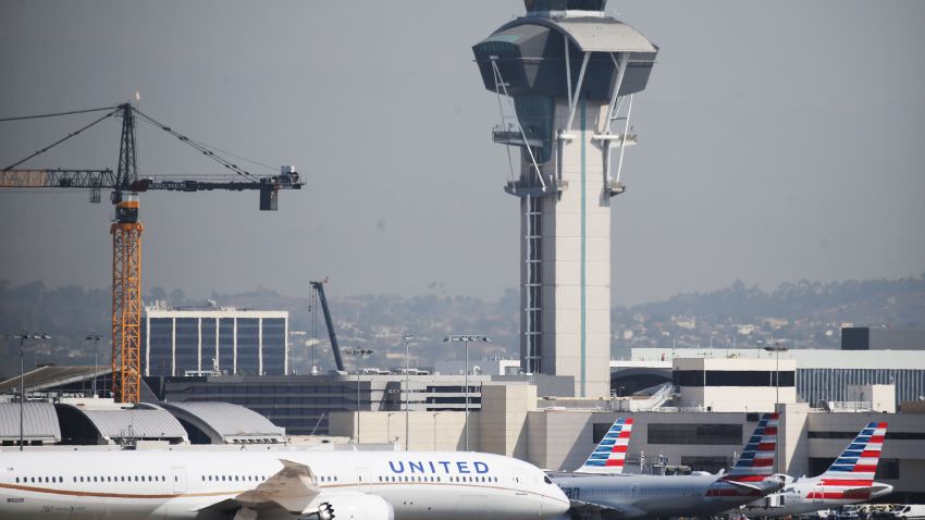 LOS ANGELES, CALIFORNIA - OCTOBER 1: A United Airlines plane passes American Airlines planes on the tarmac at Los Angeles International Airport (LAX) on October 1, 2020 in Los Angeles, California.  United Airlines and American Airlines are set to begin laying off 32,000 employees today after negotiations over a novel coronavirus aid package failed in Washington.  (Photo by Mario Tama/Getty Images)