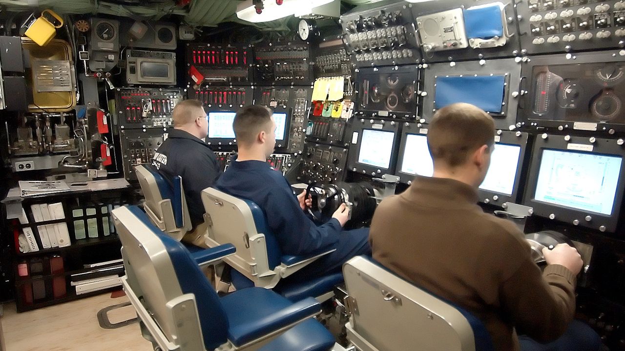 Members of the crew sit at the controls aboard the Seawolf-class attack submarine USS Jimmy Carter in 2005.