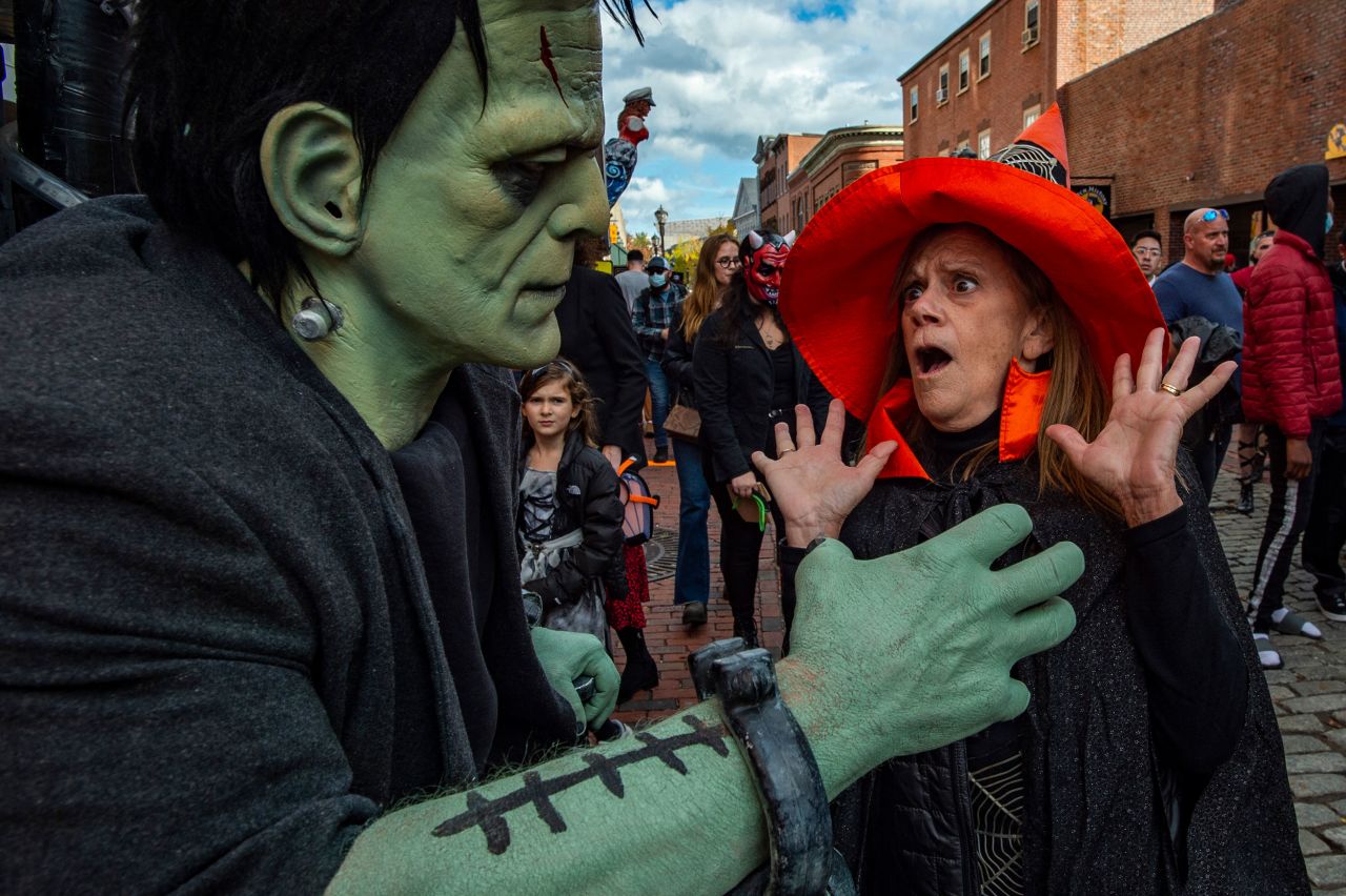 Gail DiSabatino Showghi gets a scare from a person dressed as Frankenstein's monster on Halloween in Salem, Massachusetts.