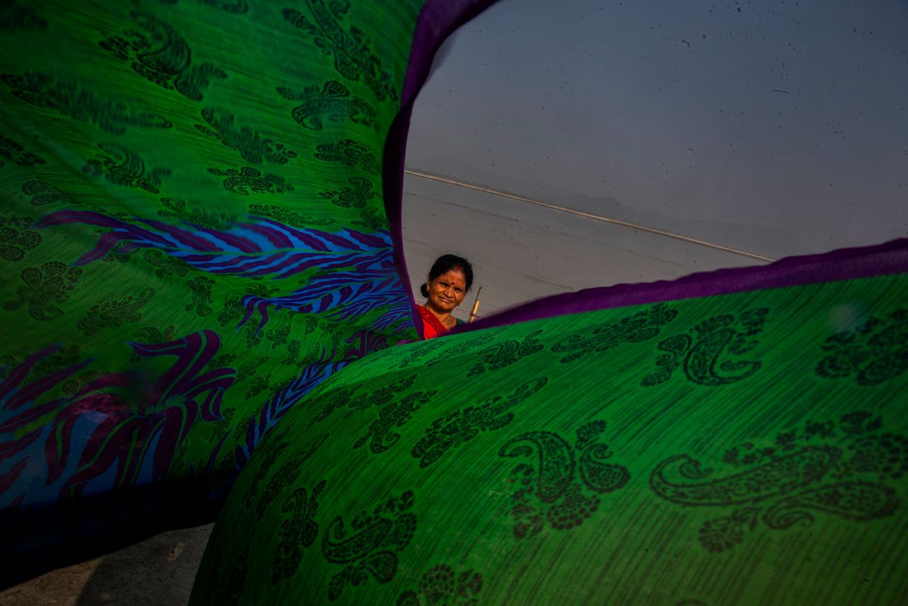 A woman dries clothes on the banks of the Brahmaputra River in Gauhati, India, on Friday, October 29.