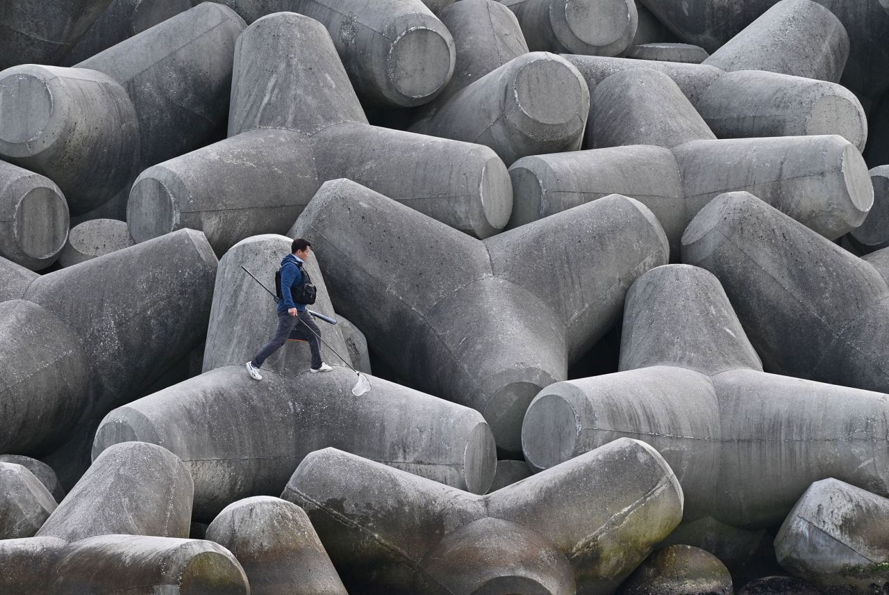 A person walks on concrete tetrapod wave breakers in Gangneung, South Korea, on Saturday, October 30.