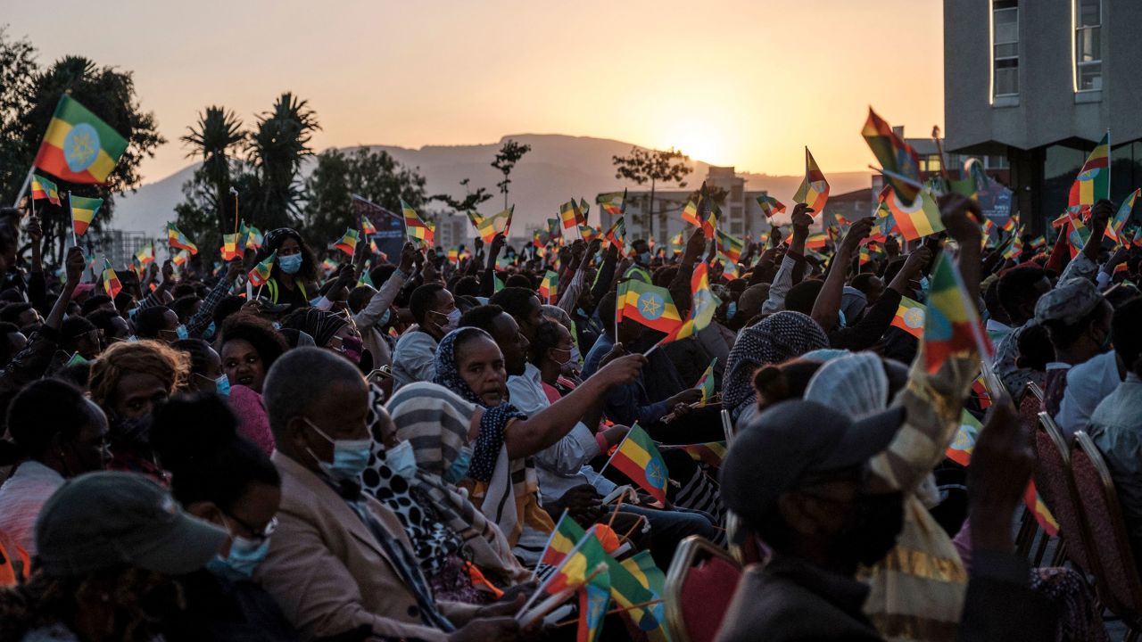 A crowd wave Ethiopian flags during a memorial service for the victims of the Tigray conflict organized by the city administration, in Addis Ababa on November 3.
