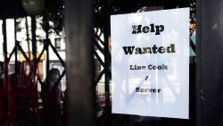 Pedestrians walk past a "Help Wanted" sign posted at restaurant looking for line cooks and servers on June 22, 2021 in Los Angeles, California.