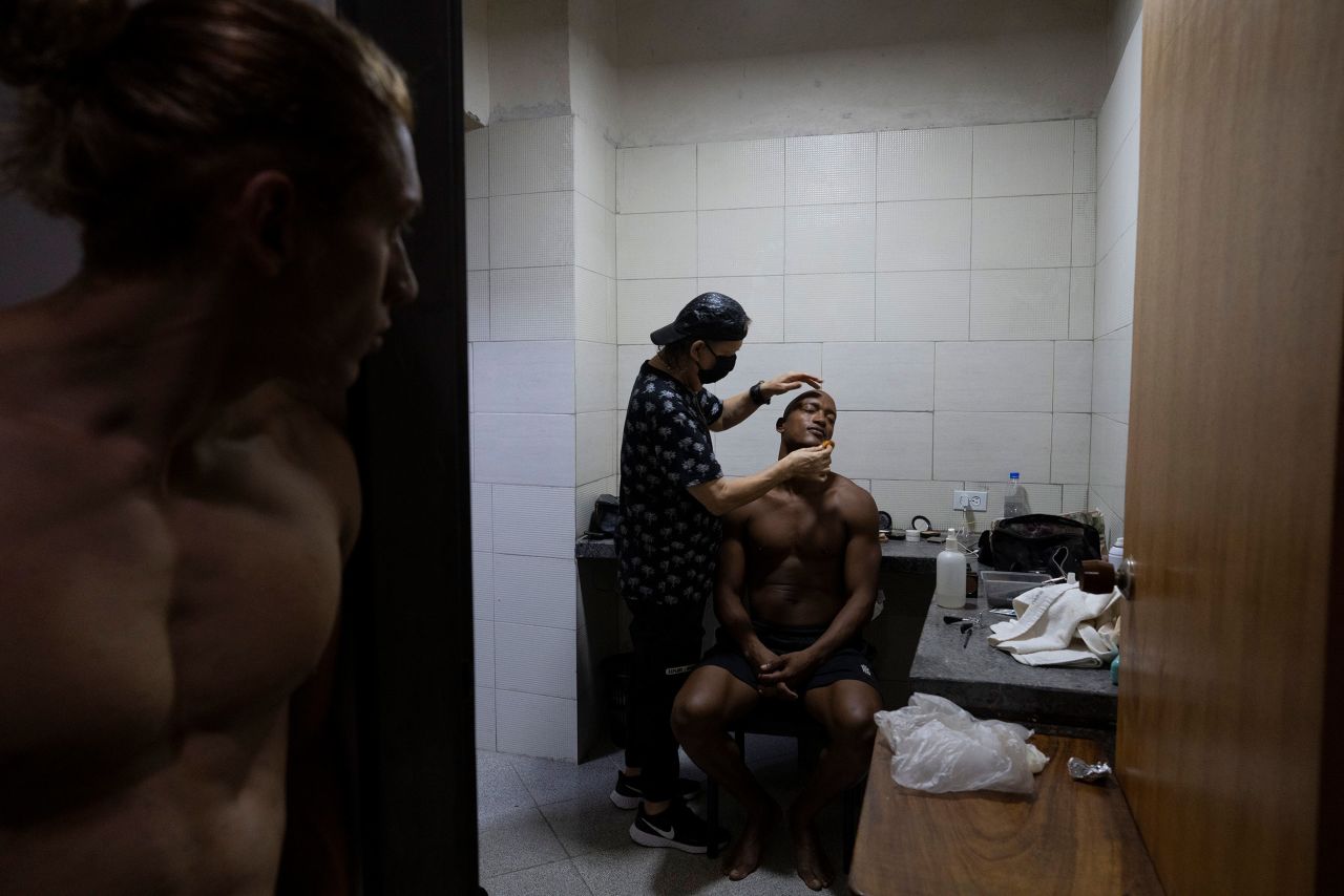 Renzo Guaramato, center, has make-up applied before the start of Mister Handsome Venezuela, a male beauty pageant, in Caracas, Venezuela, on Saturday, October 30.