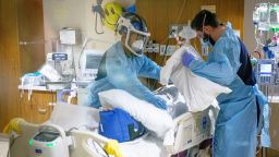 Noe Espinoza, left, a traveling registered nurse from Houston, Texas, and Dylan DeFauw, right, a traveling registered nurse from, Bethalto, Ill., care for a patient with COVID-19 on a ventilator in an ICU room at HSHS St. John's Hospital in Springfield, Ill., Thursday, October 7, 2021.
