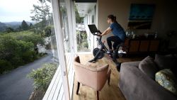 SAN ANSELMO, CALIFORNIA - APRIL 06:  Becky Friese Rodskog rides her Peloton exercise bike at her home on April 06, 2020 in San Anselmo, California.  More people are turning to Peloton due to shelter-in-place orders because of the coronavirus (COVID-19). The Peloton stock has continued to rise over recent weeks even as most of the stock market has plummeted. Peloton announced that they will temporarily pause all live classes until the end of April because an employee tested positive for coronavirus (COVID-19).  (Photo by Ezra Shaw/Getty Images)