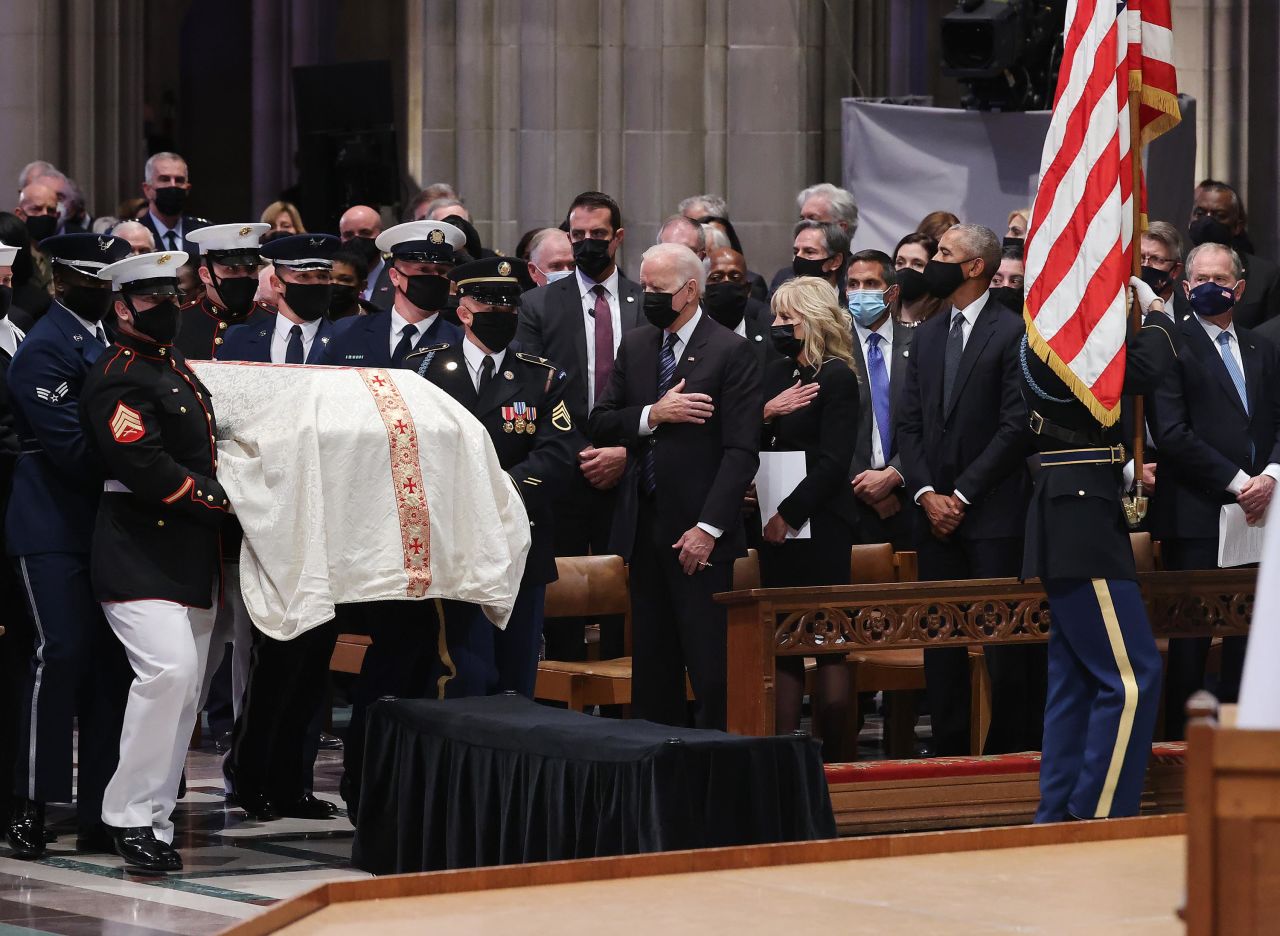 Biden watches as Powell's casket is carried during his funeral service.