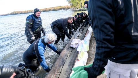 The Dane County Sheriff's dive team and the Wisconsin Historical Society team recover the 1,200 year old canoe from the bottom of Lake Mendota at Spring Harbor Beach in Madison, Wis.