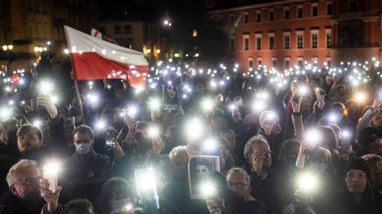 TOPSHOT - Protesters hold up lights, a Polish flag and a photograph of Iza as they take part in a demonstration on November 6, 2021 in Warsaw, Poland, to mark the first anniversary of a Constitutional Court ruling that imposed a near-total ban on abortion, and also to commemorate the death of pregnant Polish woman Iza. - Poland's Constitutional Court in 2020 sided with the Catholic country's populist right-wing government to rule that terminations over foetal defects were unconstitutional. This resulted in a further tightening of already heavy restrictions on abortions and thousands of women have sought help abroad. (Photo by Wojtek RADWANSKI / AFP) (Photo by WOJTEK RADWANSKI/AFP via Getty Images)