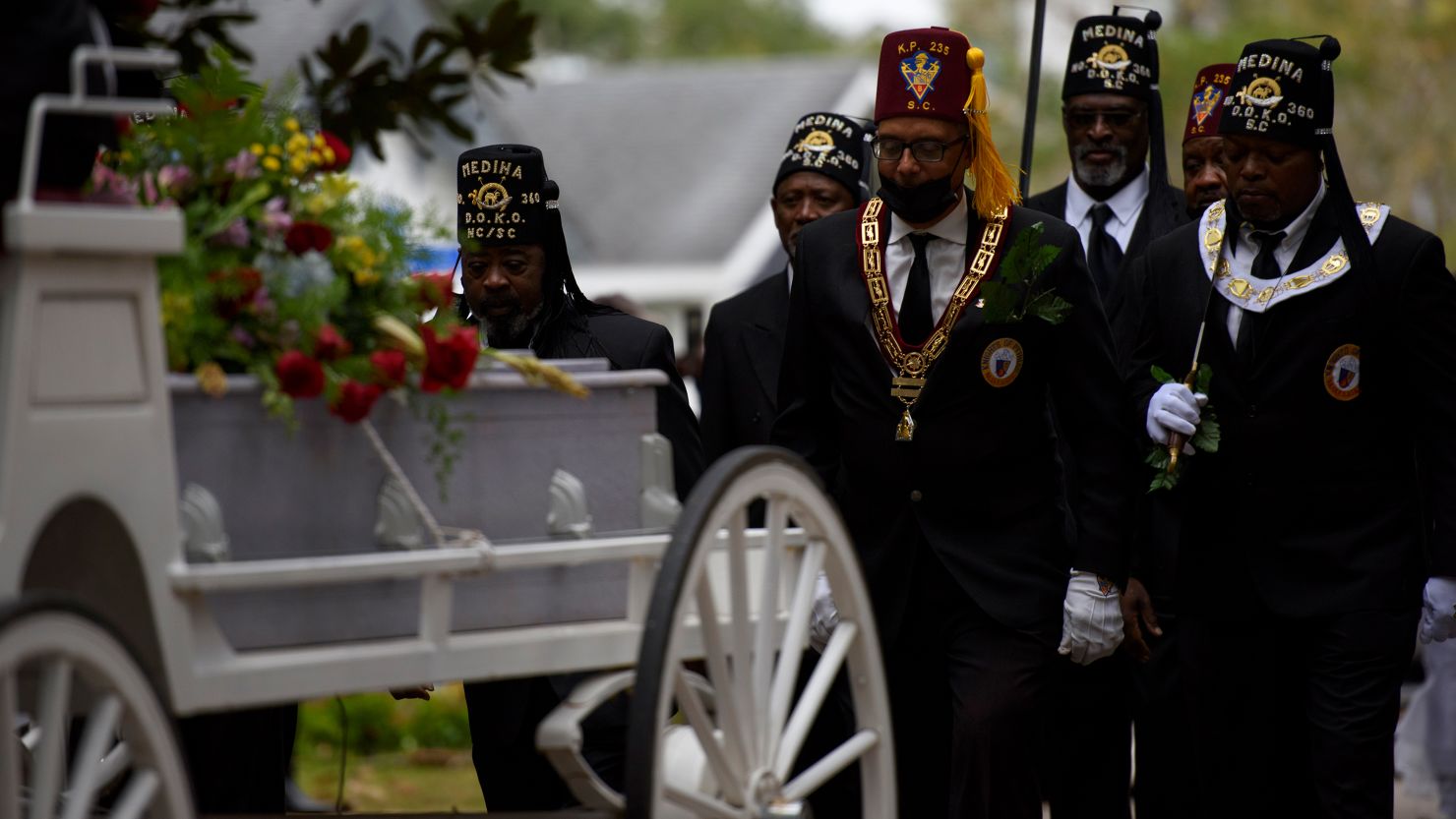 Members of a Masonic lodge and Knights of Columbus carry soil collected in honor of Joshua Halsey to his burial site.