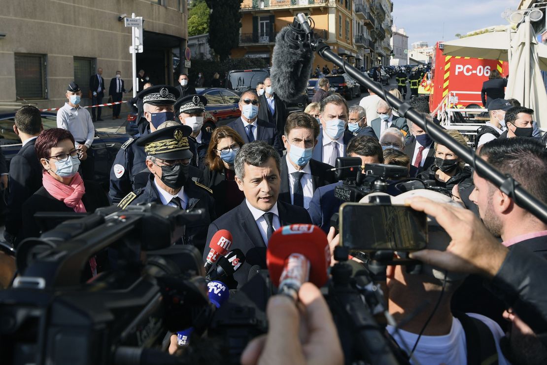 France's Interior Minister Gerald Darmanin, center, speaks to the press near the Cannes police station.