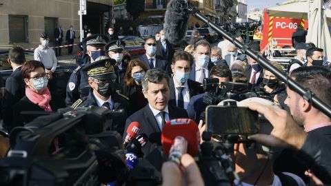 France's Interior Minister Gerald Darmanin, center, speaks to the press near the Cannes police station.