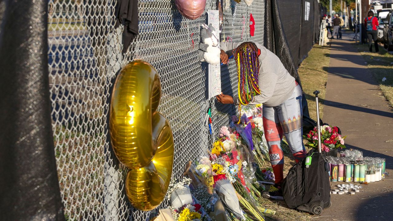 Houston resident J. Washington signs a remembrance board at a makeshift memorial Sunday at the NRG Park in Houston.