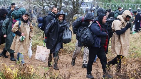 Migrants carry their belongings as they make their way towards the Poland-Belarus border on Monday.
