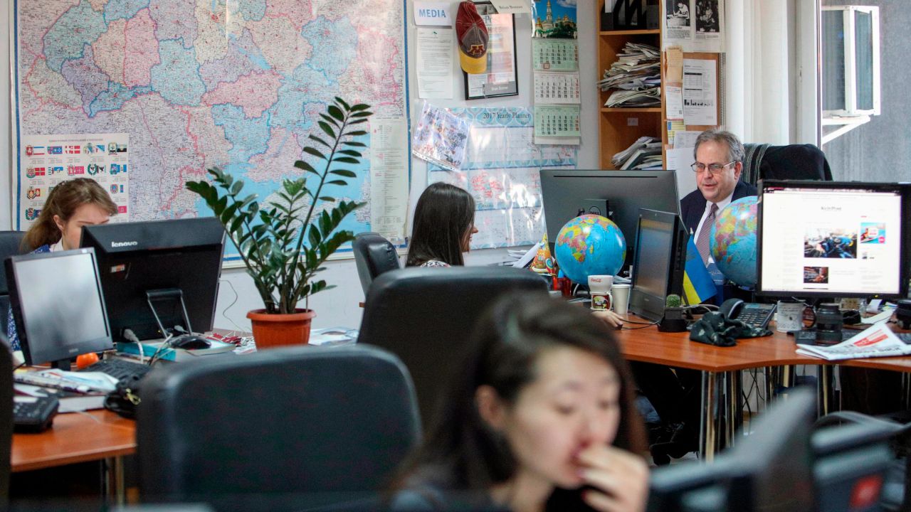 Kyiv Post chief editor Brian Bonner, right, and other journalists at their desks in 2017. 