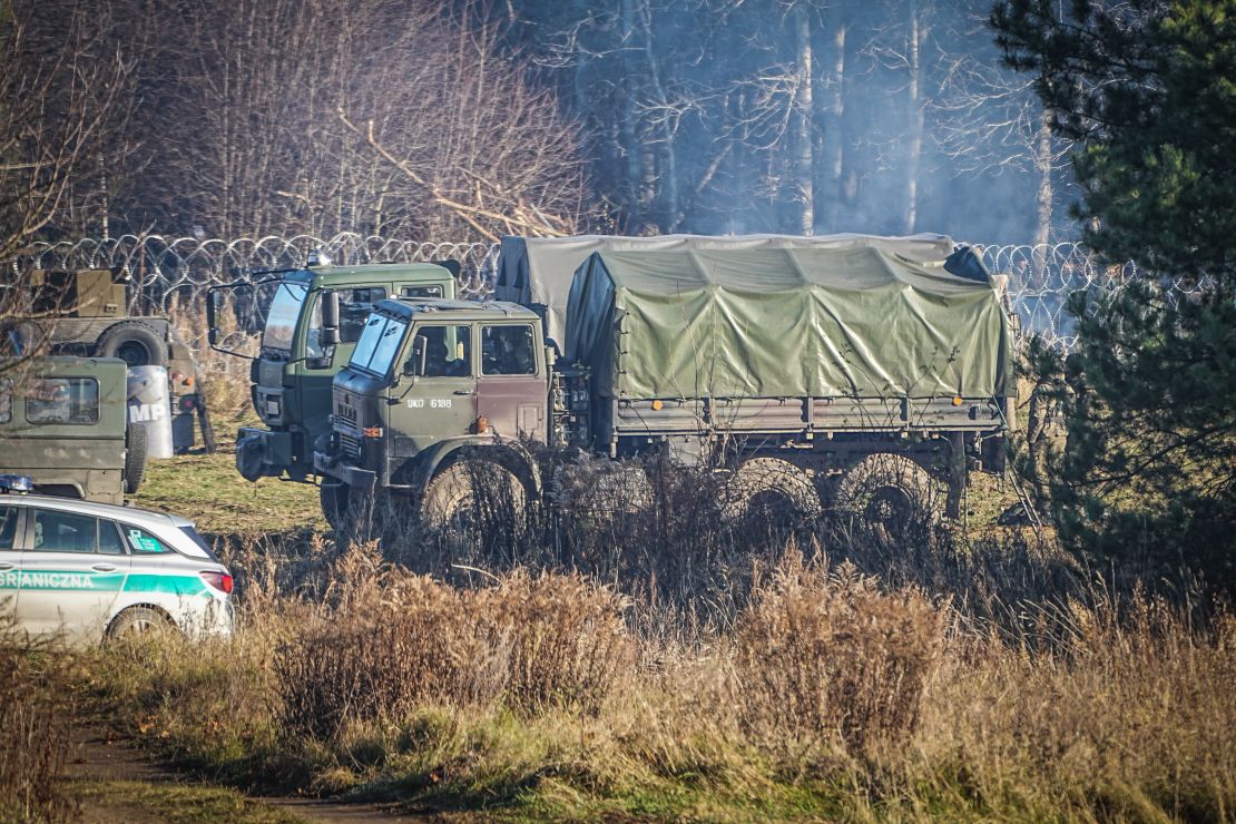 Polish army vehicles are parked along the barbed wire near the Kuznica border crossing on Tuesday. 