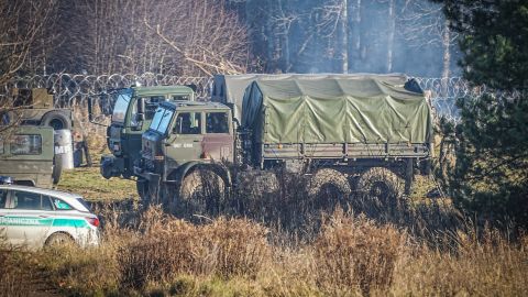Polish army vehicles are parked along the barbed wire near the Kuznica border crossing on Tuesday.