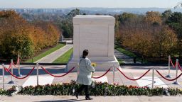 A woman arrives to place flowers during a centennial commemoration event at the Tomb of the Unknown Soldier, in Arlington National Cemetery, Tuesday, November 9, 2021, in Arlington, Virginia.