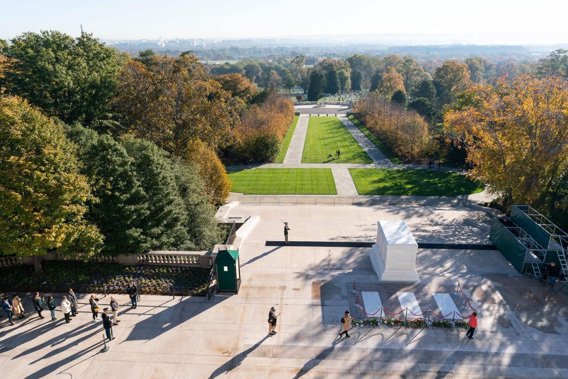 People place flowers during a centennial commemoration event at the Tomb of the Unknown Soldier, in Arlington National Cemetery in Arlington, Virginia on November 9, 2021.