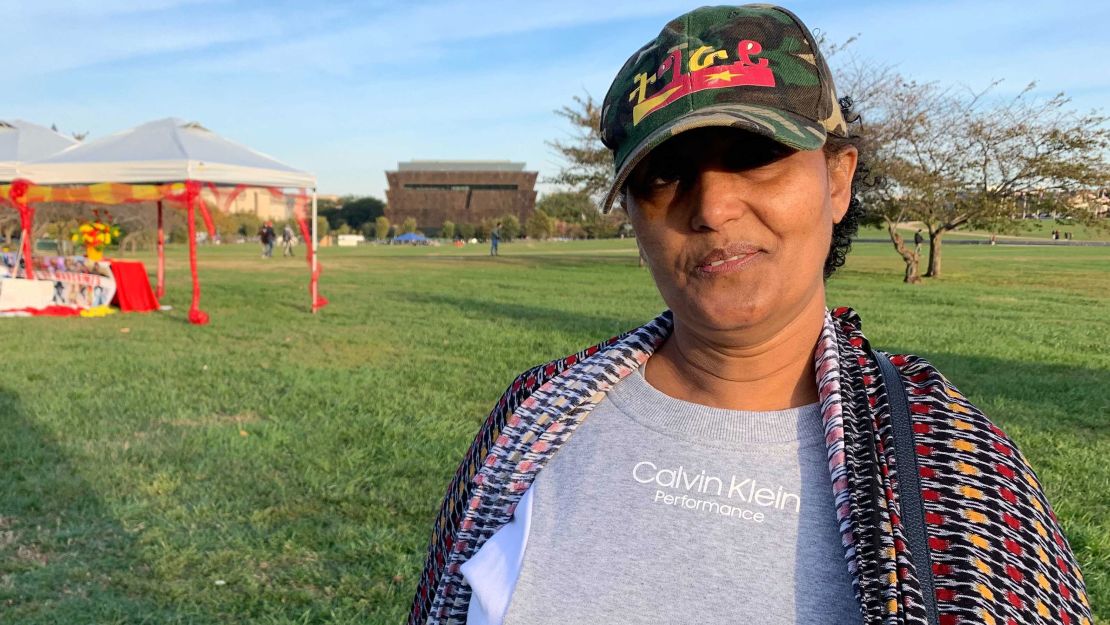 Tenagnework Abreha stands near the Washington Monument in front of a memorial to people killed in Tigray. She says the world needs to do more to help people there who are suffering.