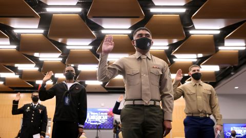 Active-duty members of the US military, including Marine Lance Cpl. Javier Reyes Salgado (C), take the oath of citizenship during a ceremony at US Citizenship and Immigration Services headquarters on Tuesday, November 9, 2021, in Camp Springs, Maryland.