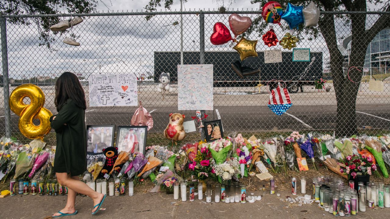 A woman walks Tuesday past a memorial outside NRG Park in Houston.