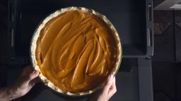 Putting pumpkin pie in the  oven top view