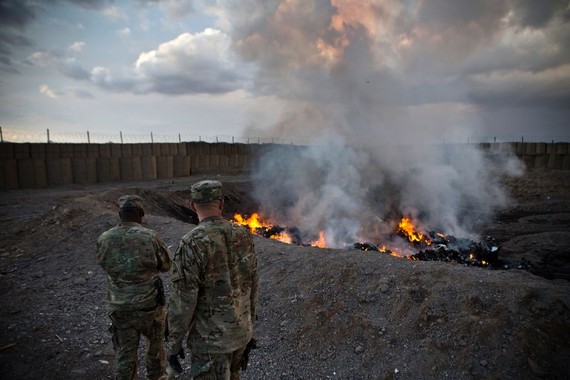 In this February 4, 2013, file photo, US soldiers watch garbage incinerate in a burn pit at Forward Operating Base Azzizulah in Afghanistan.