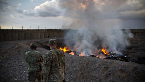 In this February 4, 2013, file photo, US soldiers watch garbage incinerate in a burn pit at Forward Operating Base Azzizulah in Afghanistan.