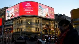 People walk past a billboard promoting the annual "Singles Day" on November 11, the biggest shopping day of the year, at a shopping mall complex in Beijing on November 10, 2021.