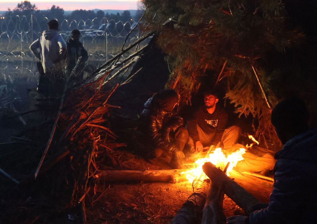 Migrants warm themselves by a bonfire in a camp on the Belarusian-Polish border on Wednesday. 