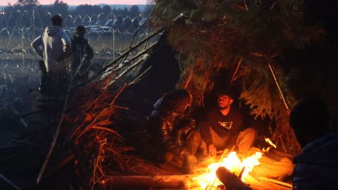 Migrants warm themselves by a bonfire in a camp on the Belarusian-Polish border on Wednesday.