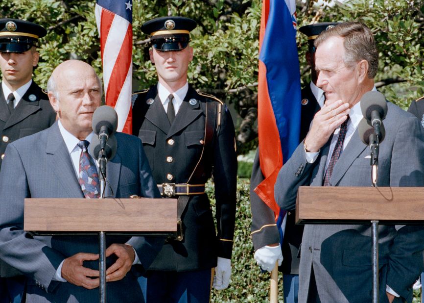 President George W. Bush listens as de Klerk addresses reporters on September 25, 1990, on the South Lawn of the White House in Washington.
