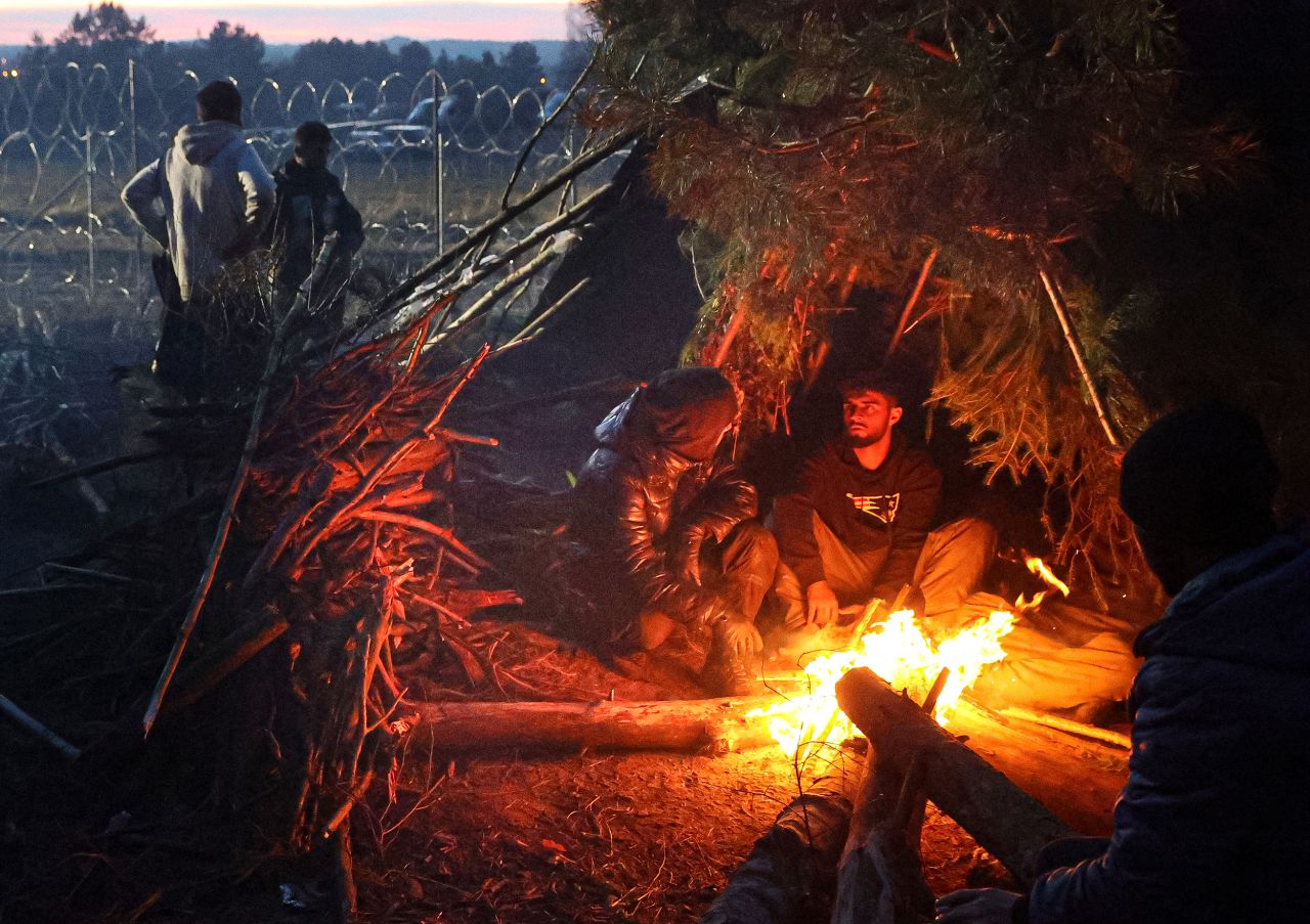 Migrants rest near a fire near the border on Wednesday, November 10.